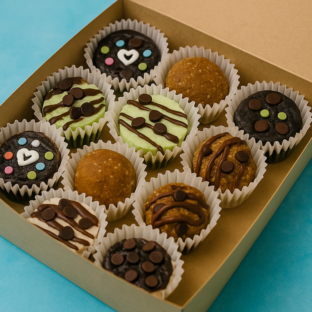 Assorted small desserts in a box on a blue background Patti's Surprise Box offers a carefully curated selection of 12 unique desserts, expertly chosen by Patti to provide a diverse and delightful tasting experience.